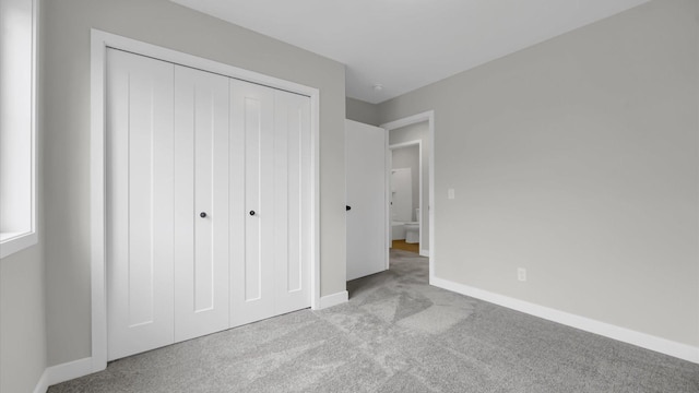 unfurnished bedroom featuring a closet and light carpet