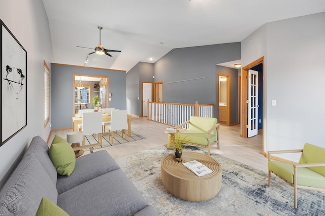 living room featuring vaulted ceiling, ceiling fan, and light hardwood / wood-style flooring