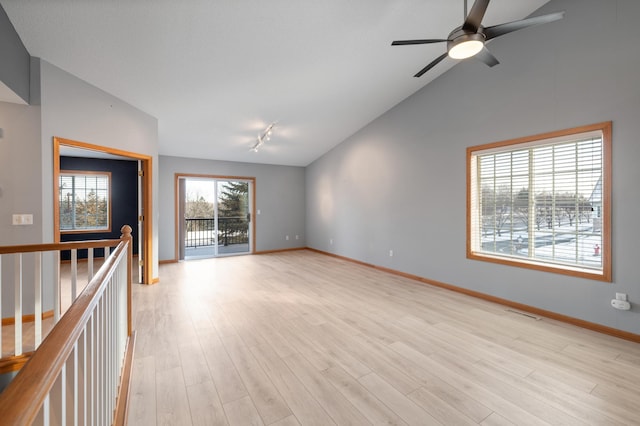 spare room featuring ceiling fan, lofted ceiling, and light wood-type flooring