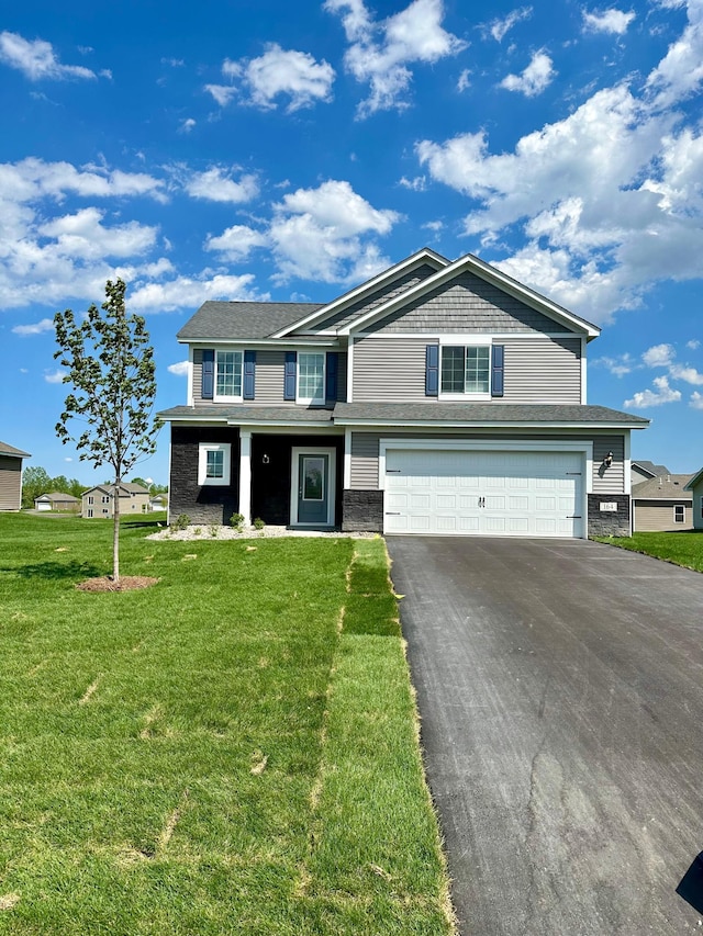 view of front of property featuring a front lawn and a garage