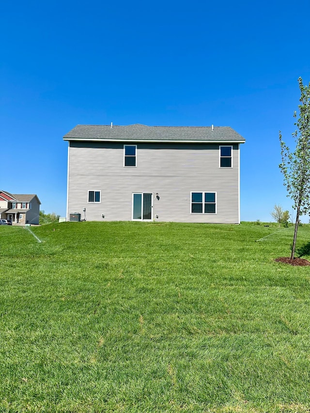 rear view of property featuring a lawn