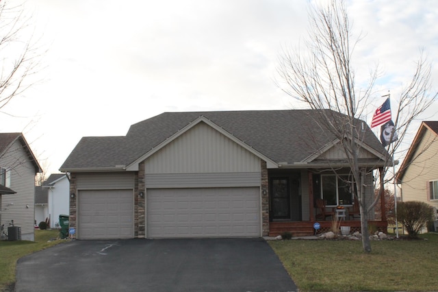 view of front of property featuring a porch, a garage, and a front lawn