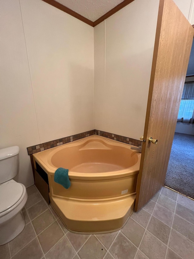 bathroom with toilet, tile patterned floors, a washtub, a textured ceiling, and crown molding