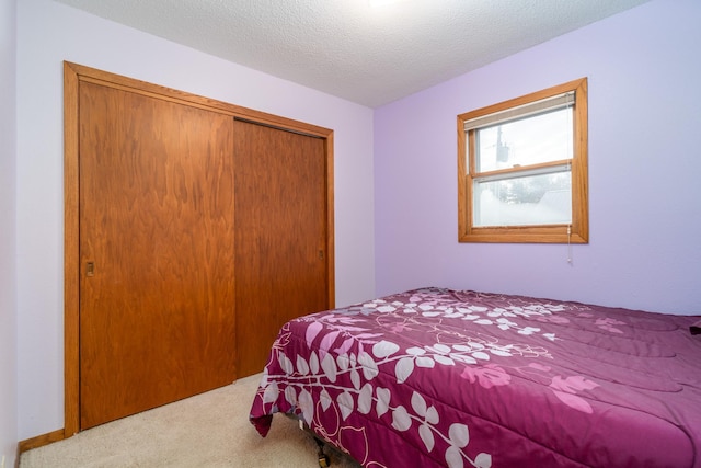 carpeted bedroom featuring a closet and a textured ceiling