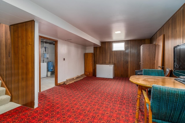 living area with wooden walls and carpet floors