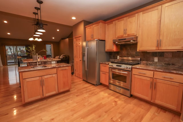 kitchen featuring sink, stainless steel appliances, tasteful backsplash, pendant lighting, and light wood-type flooring