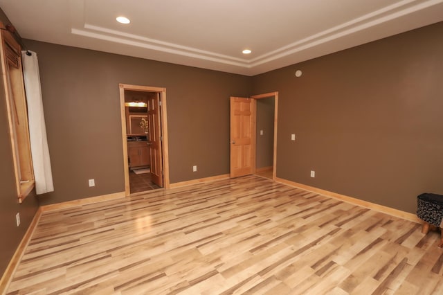 unfurnished bedroom featuring light hardwood / wood-style floors and ensuite bath