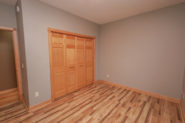 unfurnished bedroom featuring light hardwood / wood-style floors and a closet