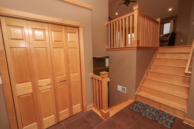 stairway featuring tile patterned floors and ceiling fan