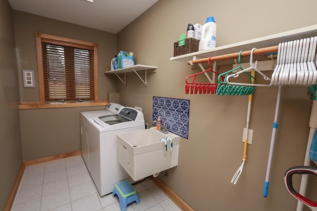 washroom with light tile patterned floors, separate washer and dryer, and sink