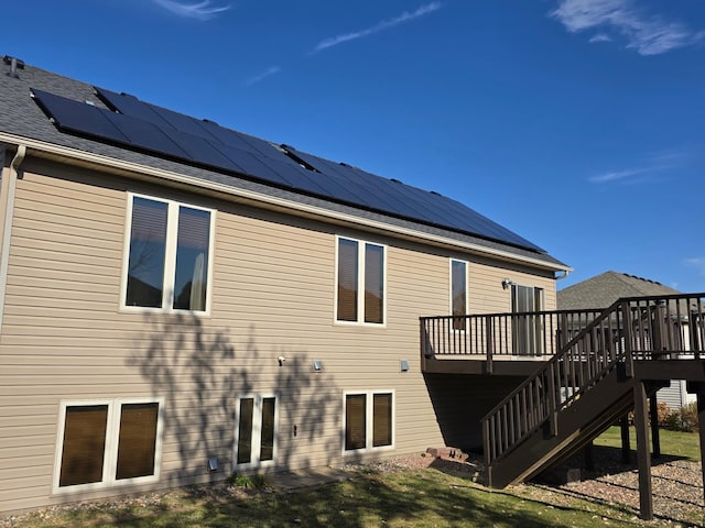 back of property featuring a deck and solar panels