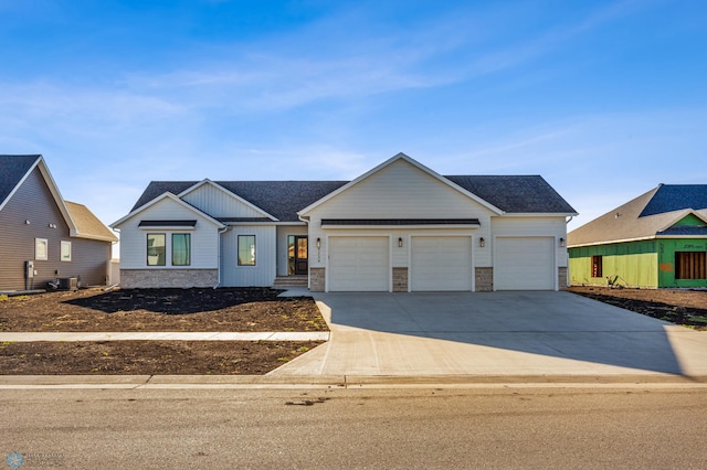 view of front of home featuring central air condition unit and a garage