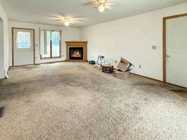 unfurnished living room with ceiling fan and carpet floors