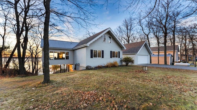 view of front facade with a garage, a yard, and an outbuilding