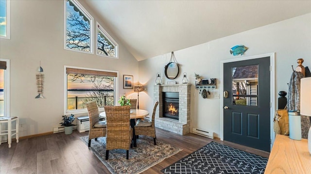 dining area with baseboard heating, a fireplace, dark hardwood / wood-style flooring, and high vaulted ceiling