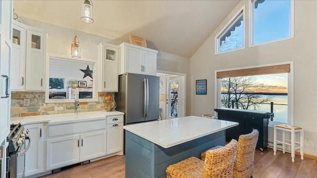 kitchen featuring white cabinets, a center island, backsplash, and stainless steel appliances