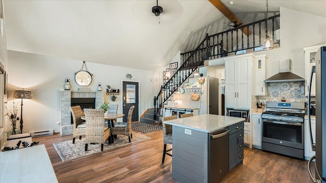 kitchen with stainless steel appliances, wall chimney range hood, beamed ceiling, white cabinets, and a center island