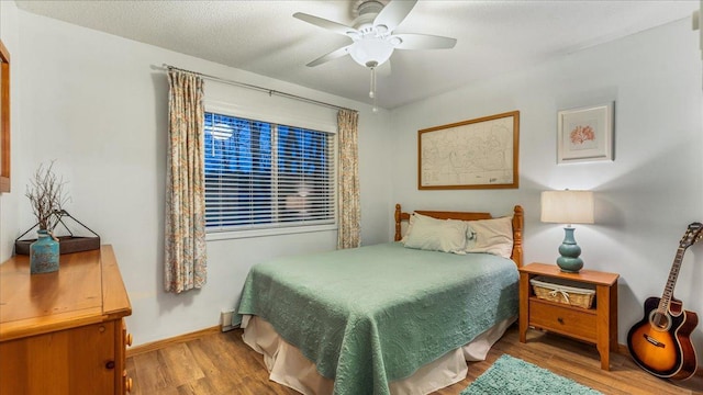 bedroom featuring ceiling fan, wood-type flooring, and a textured ceiling