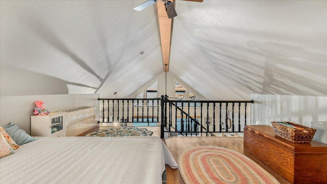 bedroom with ceiling fan, hardwood / wood-style floors, and vaulted ceiling