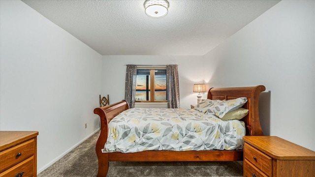 bedroom with dark colored carpet and a textured ceiling