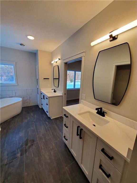 bathroom featuring vanity, a tub, and tile walls