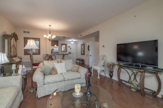 living room with wood-type flooring and a notable chandelier