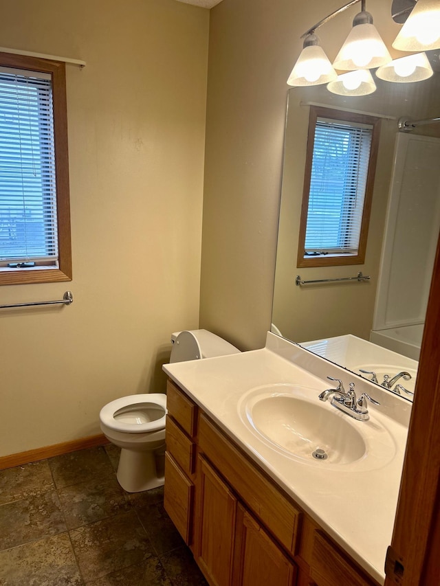 bathroom with vanity, a chandelier, and toilet