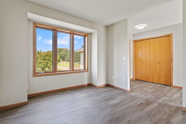 interior space featuring a textured ceiling and light hardwood / wood-style floors