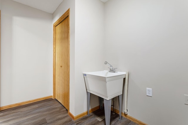 laundry area with dark hardwood / wood-style flooring