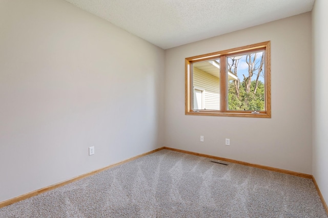 carpeted empty room with a textured ceiling