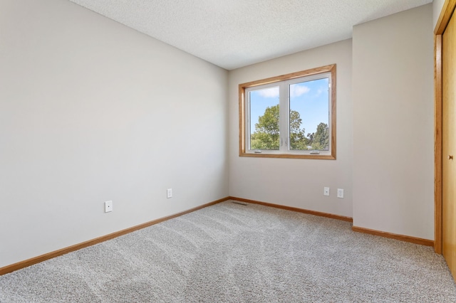 carpeted empty room with a textured ceiling