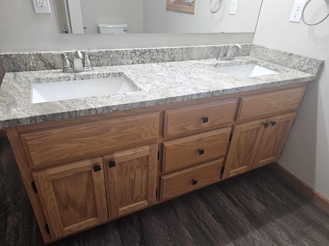 bathroom with hardwood / wood-style flooring, vanity, and toilet