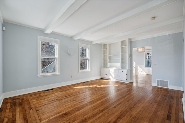 empty room with hardwood / wood-style floors, built in features, and beam ceiling