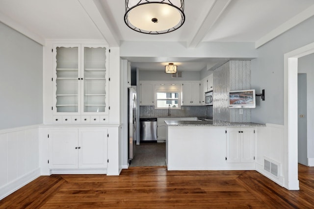 kitchen with stainless steel appliances, dark hardwood / wood-style flooring, white cabinets, decorative backsplash, and light stone countertops