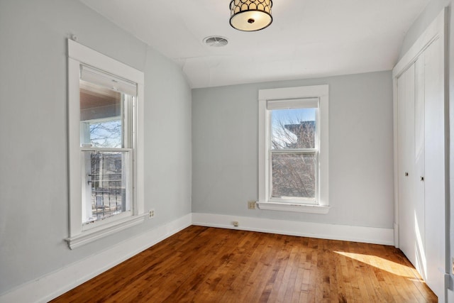 spare room with hardwood / wood-style floors and plenty of natural light