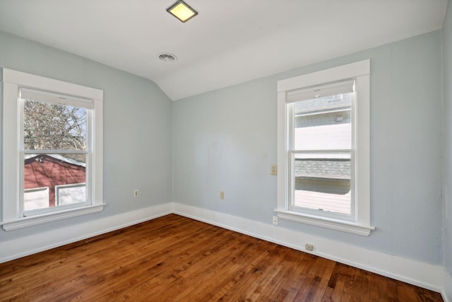 empty room with lofted ceiling and hardwood / wood-style floors