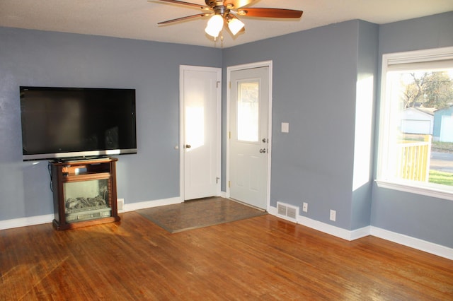 unfurnished living room with hardwood / wood-style floors, ceiling fan, and a healthy amount of sunlight