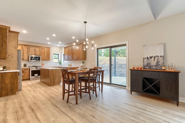 dining area featuring light hardwood / wood-style floors and an inviting chandelier