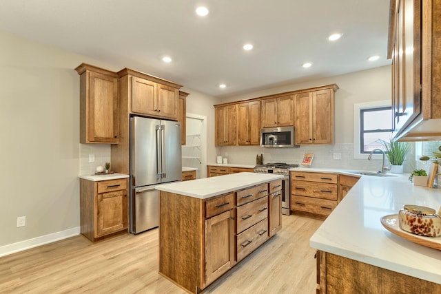 kitchen with light wood-type flooring, a kitchen island, high end appliances, and a sink