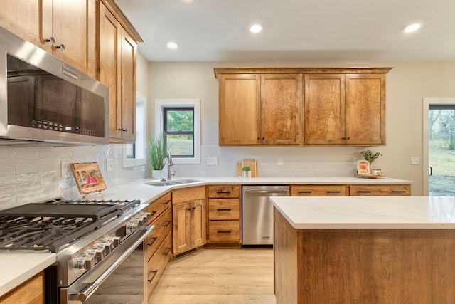 kitchen with a sink, tasteful backsplash, appliances with stainless steel finishes, and a wealth of natural light