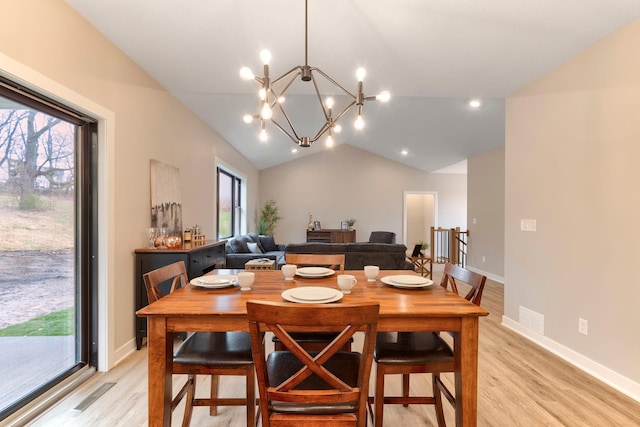 dining room featuring a notable chandelier, lofted ceiling, light wood-type flooring, and visible vents