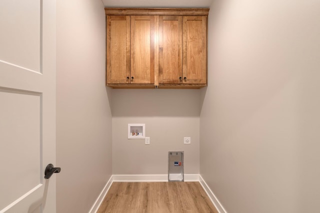 laundry area featuring light wood finished floors, baseboards, hookup for a washing machine, cabinet space, and hookup for an electric dryer