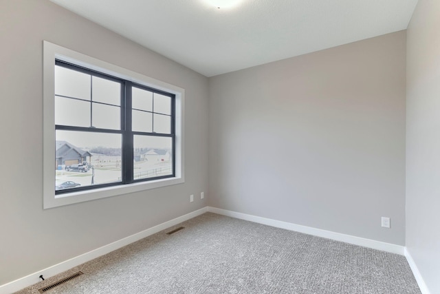 spare room featuring visible vents, baseboards, and carpet floors