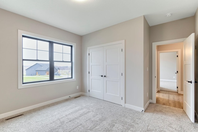 unfurnished bedroom featuring visible vents, baseboards, and carpet flooring