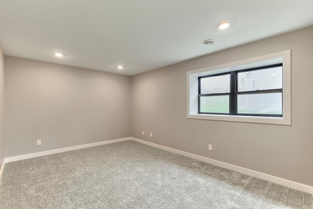 empty room featuring recessed lighting, baseboards, and carpet