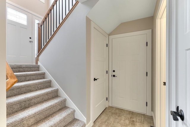 foyer with stairway and lofted ceiling