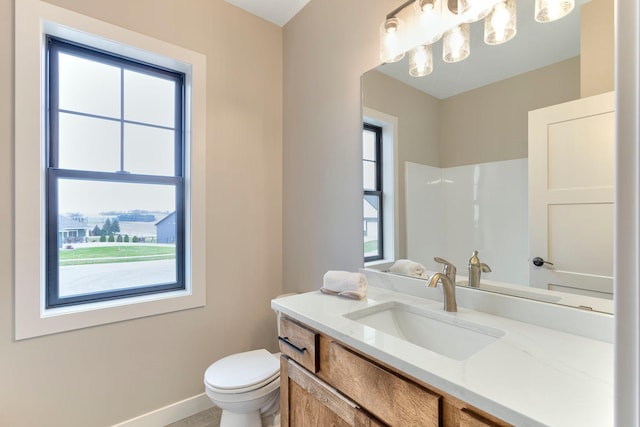 bathroom featuring vanity, toilet, baseboards, and a chandelier