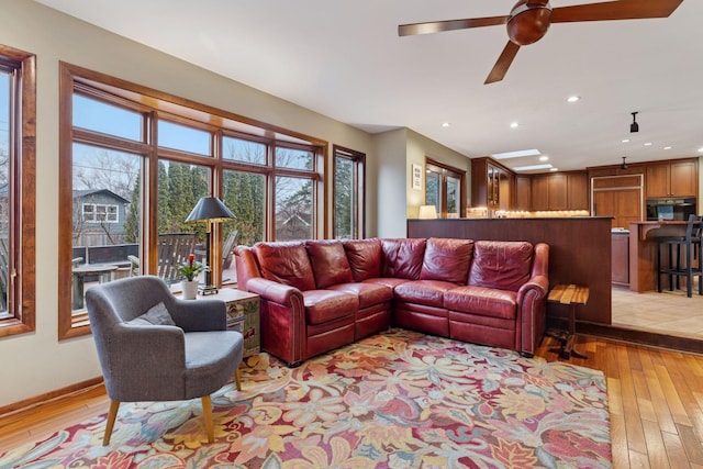 living room featuring a ceiling fan, light wood-style flooring, recessed lighting, and baseboards