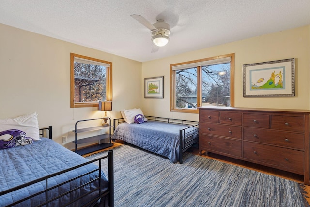 bedroom featuring a textured ceiling, ceiling fan, and wood finished floors