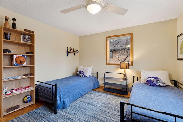 bedroom featuring a textured ceiling, wood finished floors, and a ceiling fan